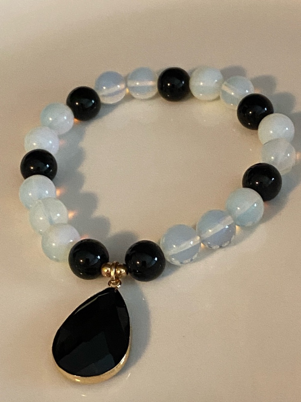 Opalescent White and Black Beaded Bracelet with Black Teardrop Pendant